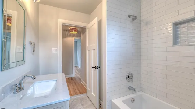 a bathroom with a tub a sink and a large mirror