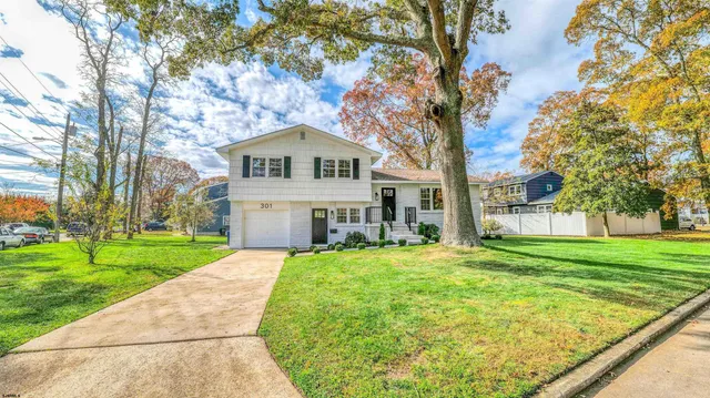 a front view of a house with yard and green space