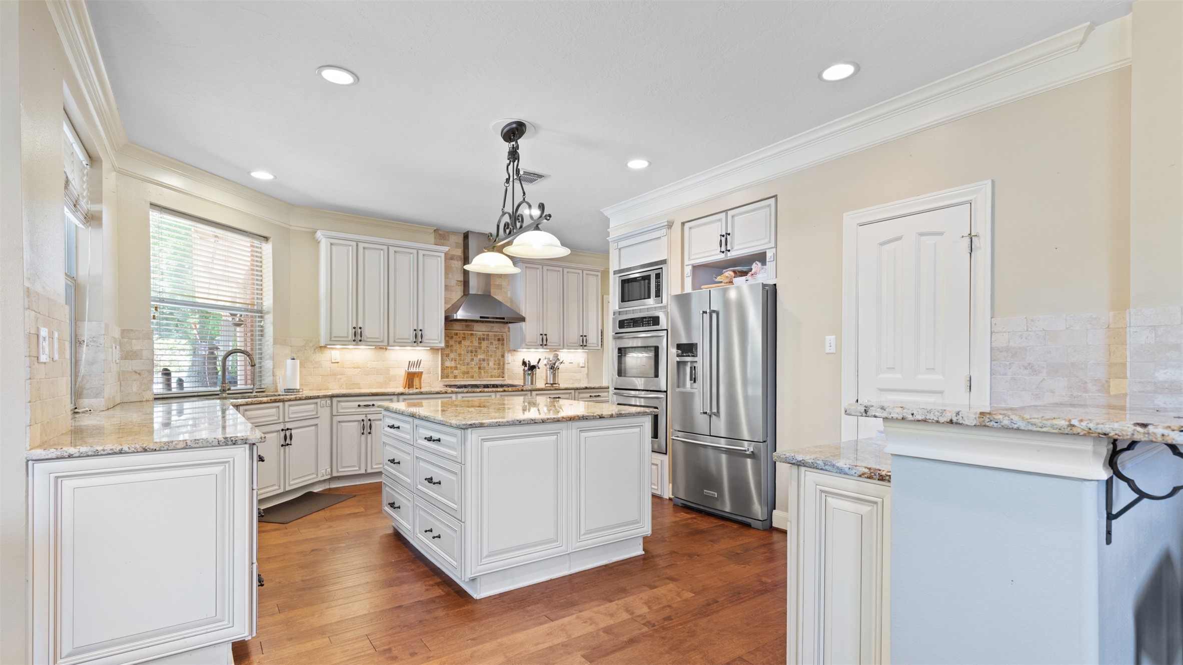 37703 Edgewater Drive Pinehurst, TX 77362 - Photo 14 of 37 a kitchen with stainless steel appliances a sink cabinets and wooden floor