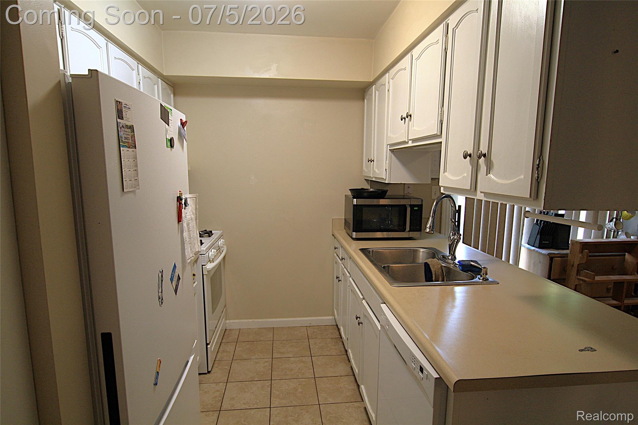 12403 Willard Road Montrose, MI 48457 - Photo 12 of 30 Kitchen featuring light countertops, white appliances, white cabinetry, and light tile patterned flooring