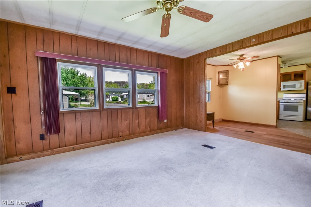 112 Lakeside Way Southwest Warren, OH 44481 - Photo 5 of 16 Living area featuring wood-finish paneling and carpeted flooring