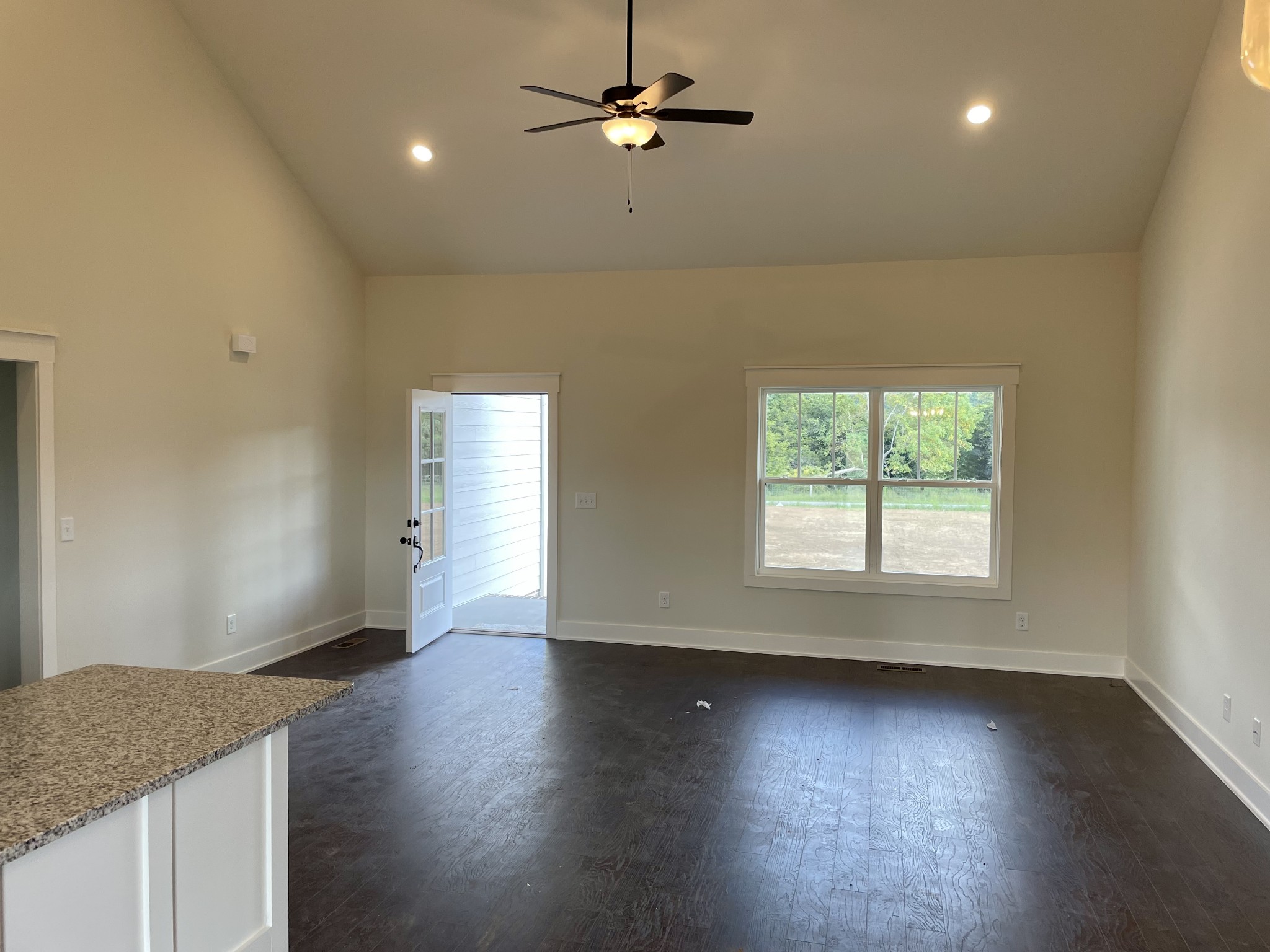 249 Tom Ferrell Road Portland, TN 37148 - Photo 11 of 28 an empty room with wooden floor chandelier fan and windows