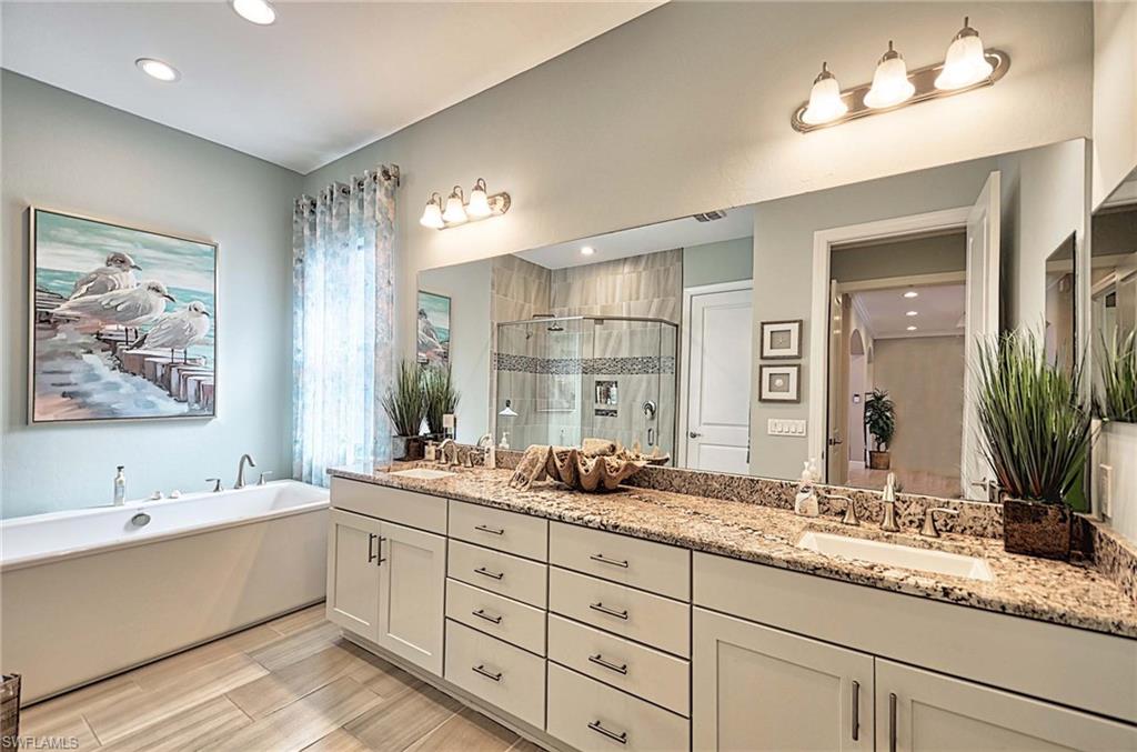 2166 Antigua Lane Naples, FL 34120 - Photo 15 of 35 a bathroom with double vanity sinks a large mirror and a shower