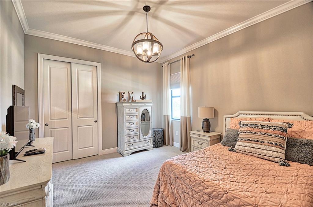 2166 Antigua Lane Naples, FL 34120 - Photo 17 of 35 a bedroom with a bed and a chandelier