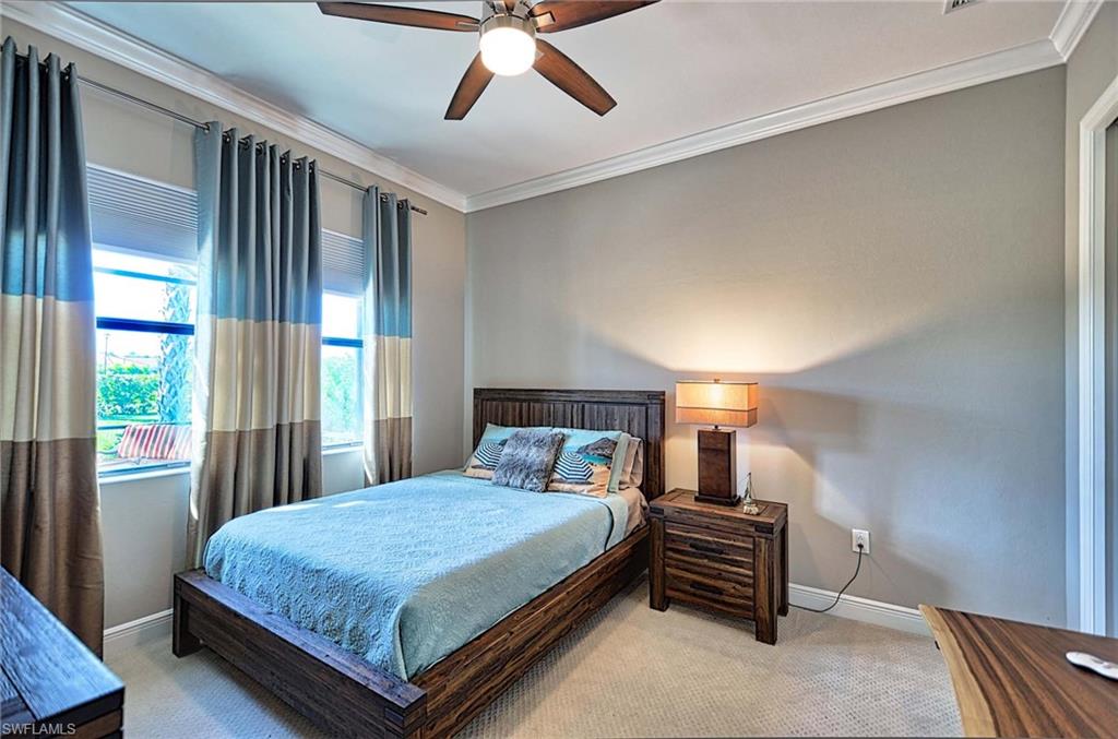 2166 Antigua Lane Naples, FL 34120 - Photo 19 of 35 a bedroom with a large bed and a chandelier