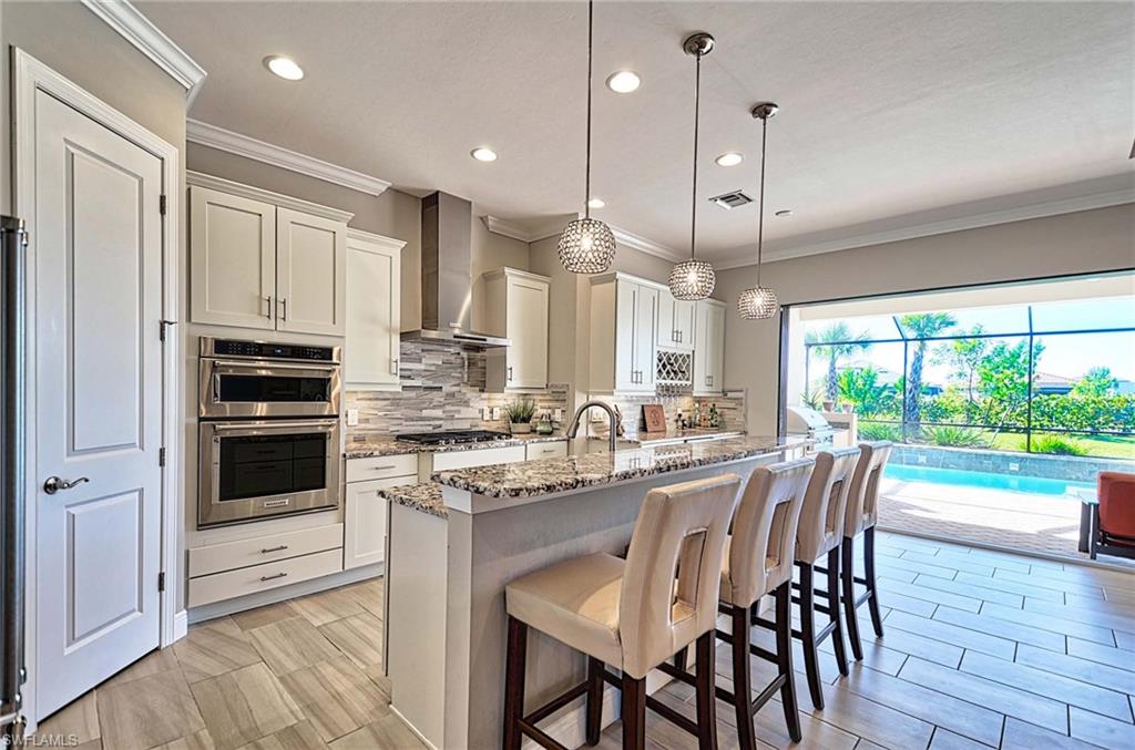 2166 Antigua Lane Naples, FL 34120 - Photo 3 of 35 a kitchen with kitchen island a large counter top space appliances and cabinets