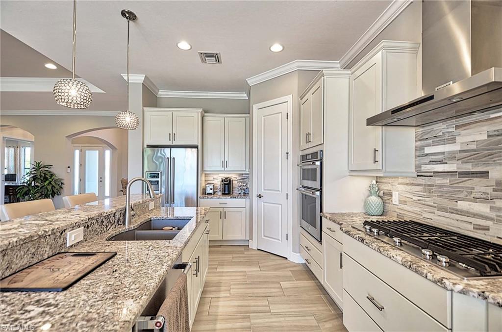 2166 Antigua Lane Naples, FL 34120 - Photo 4 of 35 a kitchen with granite countertop kitchen island stainless steel appliances a sink stove and refrigerator