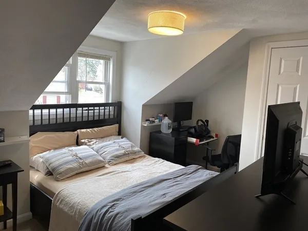 a bedroom with a bed and a tv on table