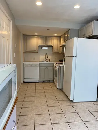 a kitchen with refrigerator cabinets and wooden floor