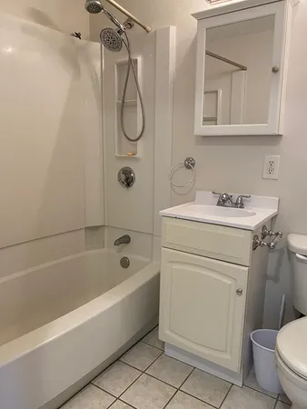 a bathroom with a sink a mirror toilet and bathtub