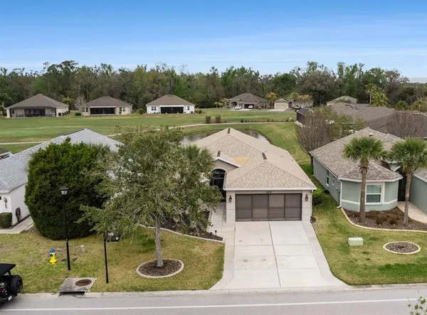 an aerial view of a house with yard and mountain view in back