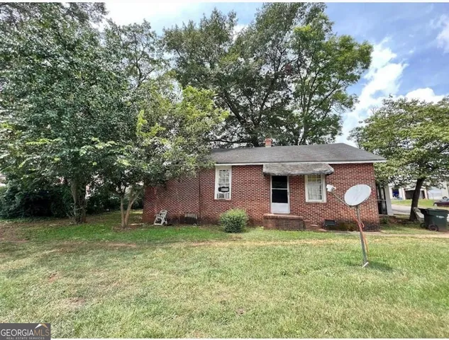 a front view of house with a garden