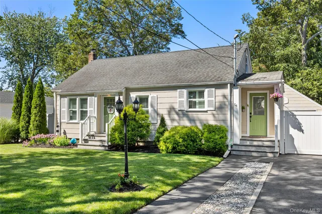a front view of a house with a yard and plants
