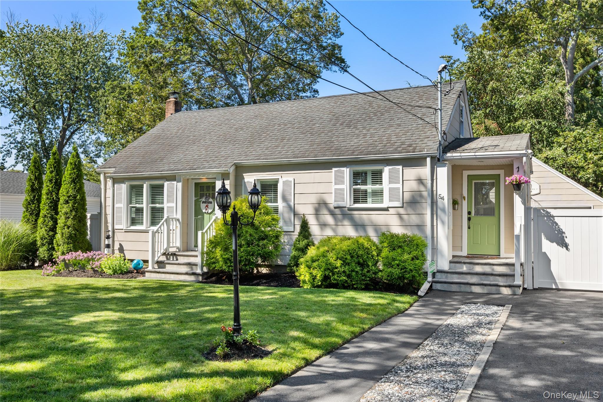 54 Rowland Street Patchogue, NY 11772 - Photo 1 of 1 a front view of a house with a yard and plants