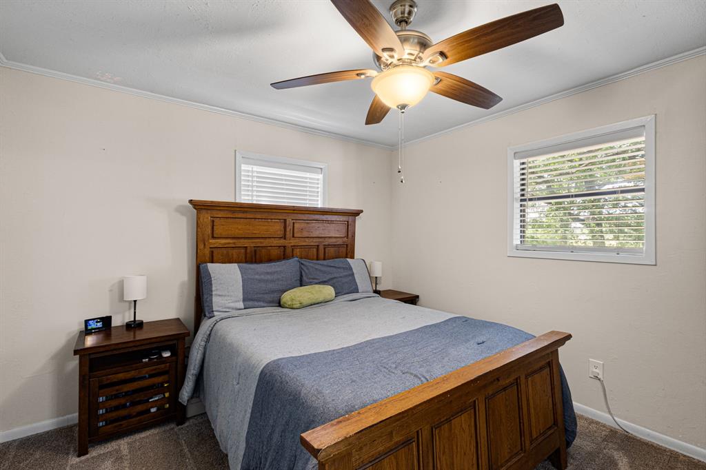 818 Country Club Road Bowie, TX 76230 - Photo 18 of 34 a bedroom with a bed and a chandelier