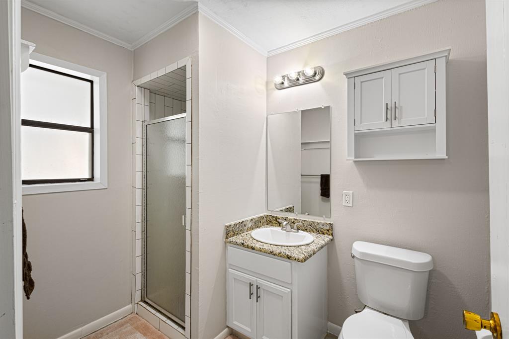 818 Country Club Road Bowie, TX 76230 - Photo 19 of 34 a bathroom with a sink a toilet and mirror