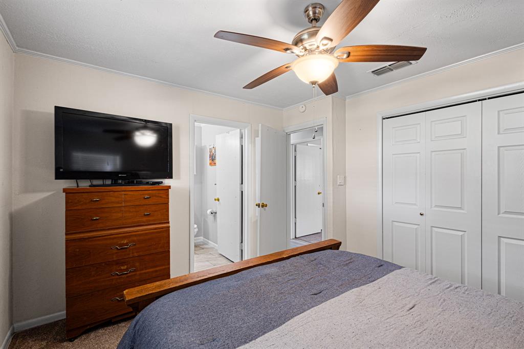 818 Country Club Road Bowie, TX 76230 - Photo 20 of 34 a bedroom with a bed and a flat screen tv