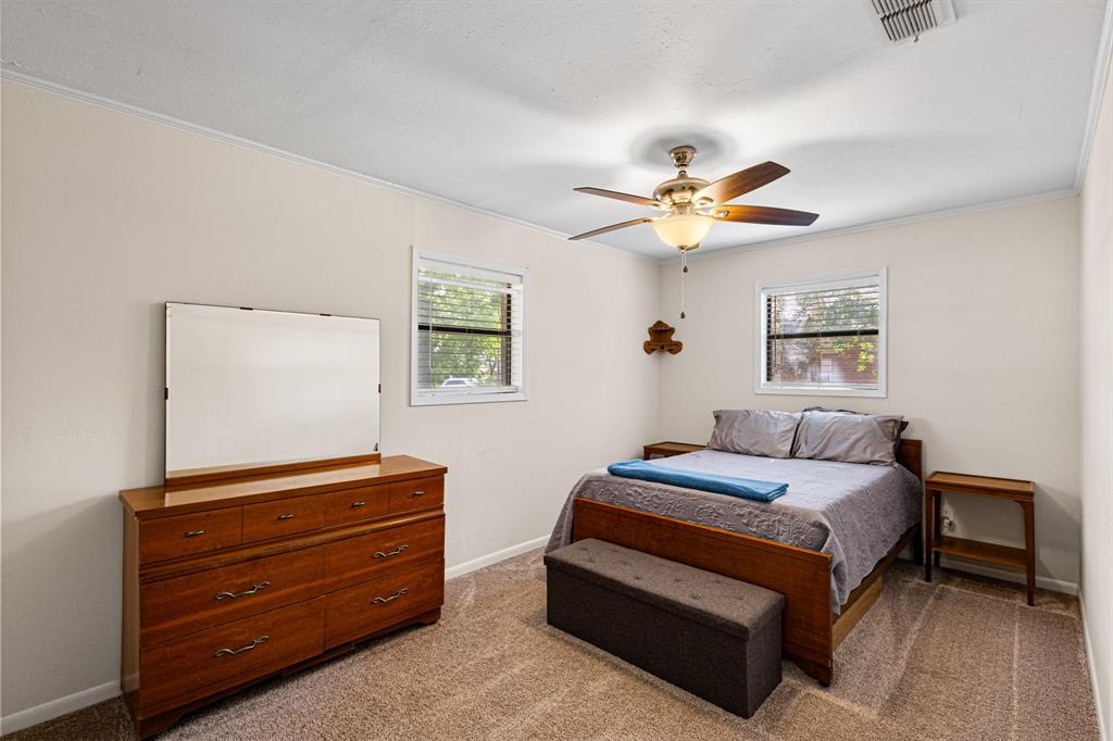 818 Country Club Road Bowie, TX 76230 - Photo 25 of 34 a bedroom with a bed and a ceiling fan