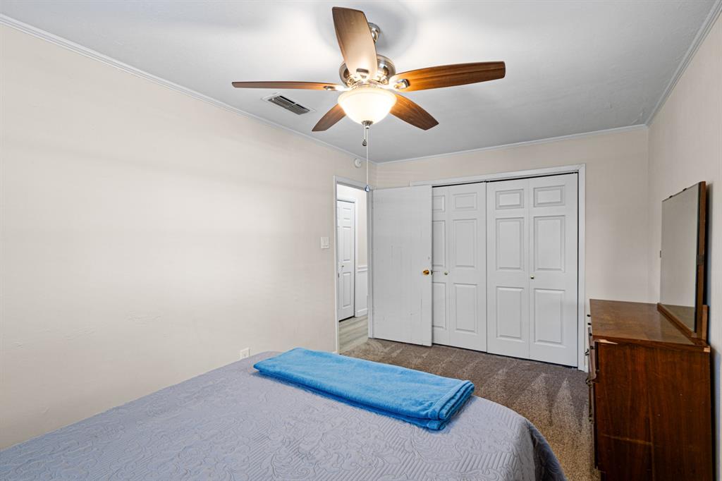 818 Country Club Road Bowie, TX 76230 - Photo 26 of 34 a bedroom with a bed and a chandelier