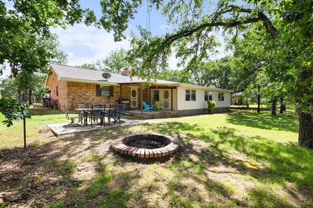 a view of a house with backyard sitting area and garden