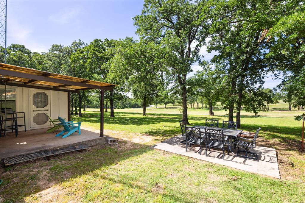 818 Country Club Road Bowie, TX 76230 - Photo 29 of 34 a view of a house with backyard sitting area and garden