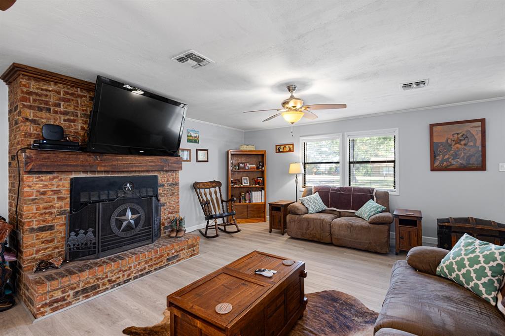 818 Country Club Road Bowie, TX 76230 - Photo 4 of 34 a living room with furniture and a flat screen tv