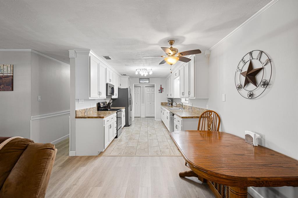 818 Country Club Road Bowie, TX 76230 - Photo 6 of 34 a kitchen with stainless steel appliances a table and chairs