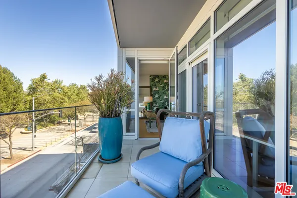 a view of a chairs and table in the balcony
