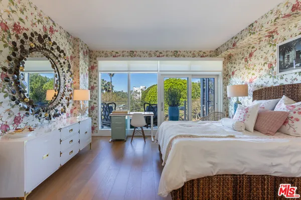 a bedroom with a large bed and a flat tv screen on dresser