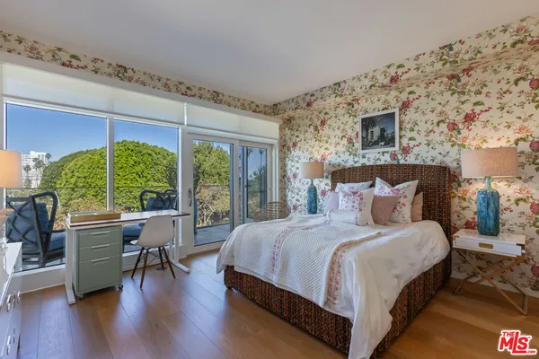 a bedroom with a large bed and windows