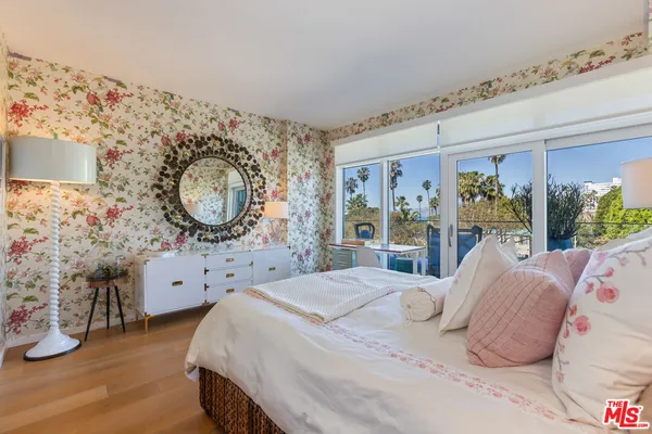 a bedroom with a bed mirror and window