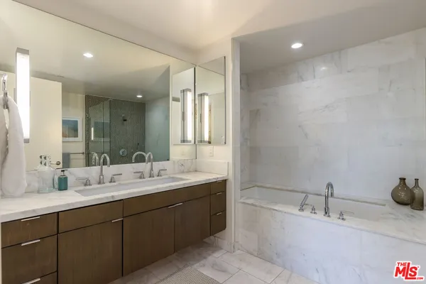 a bathroom with a bathtub double sink and mirror