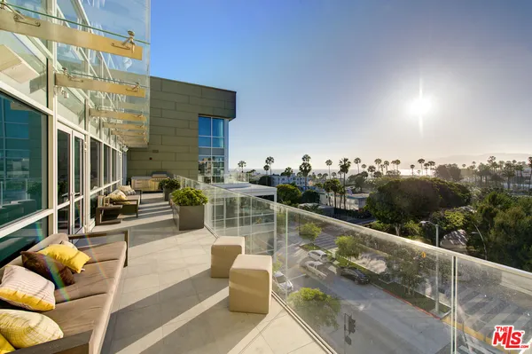 a view of roof deck with couches and sky view
