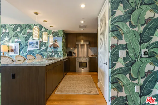 a view of a kitchen with kitchen island a counter top space and stainless steel appliances