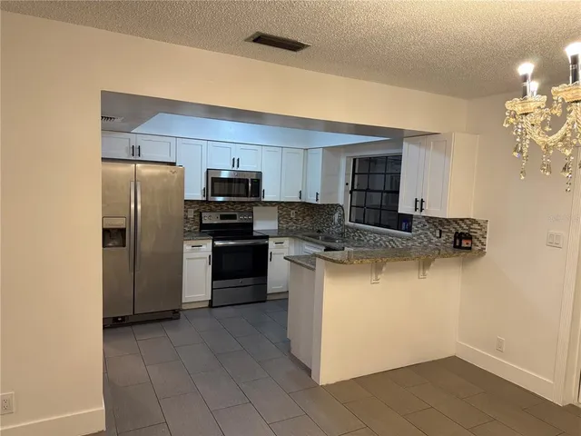 a kitchen with a refrigerator a stove top oven and a sink