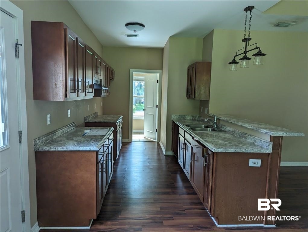 659 Bond Street Mobile, AL 36607 - Photo 4 of 10 Kitchen with hanging light fixtures, sink, dark hardwood / wood-style flooring, and ventilation hood