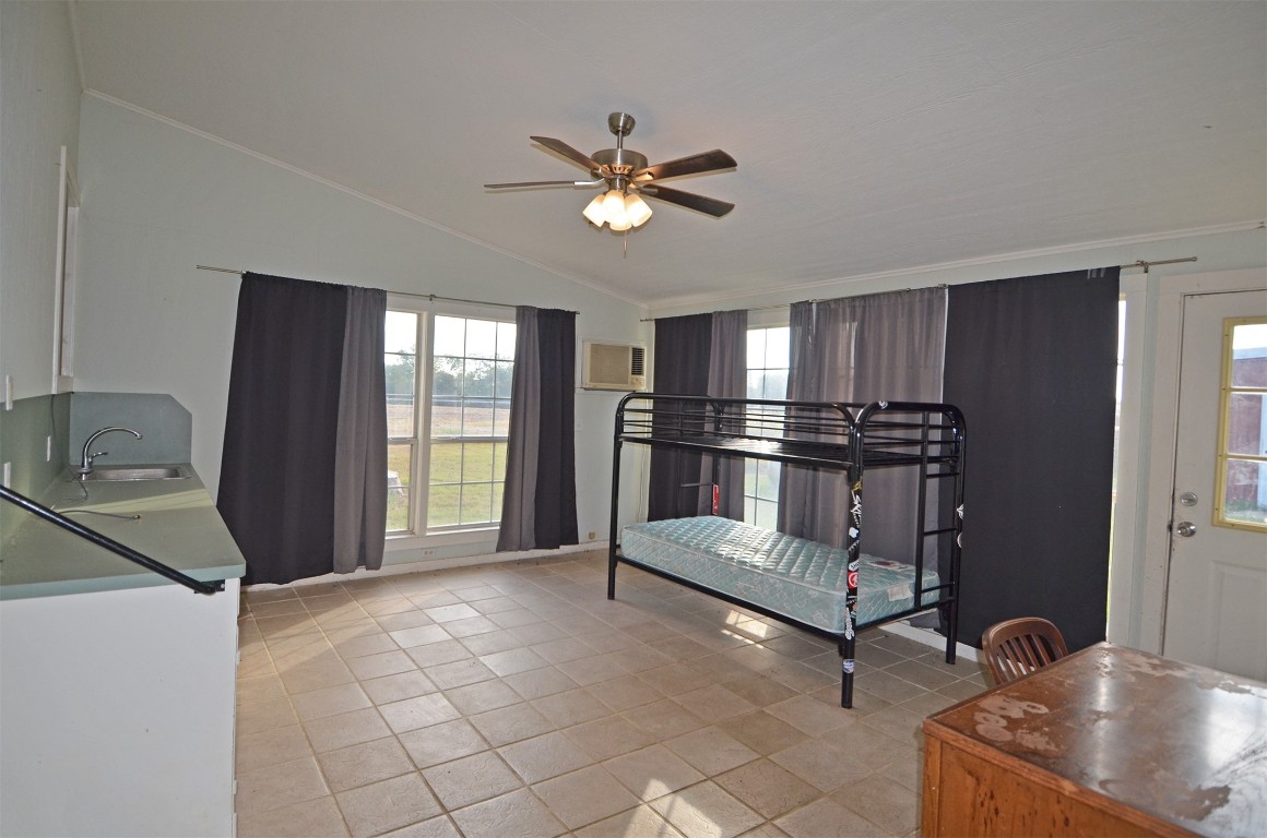 2352 Airport Road Brenham, TX 77833 - Photo 13 of 24 a kitchen with kitchen island a counter top space appliances and a ceiling fan