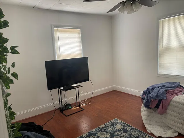a front view of a house with a yard and a large tree