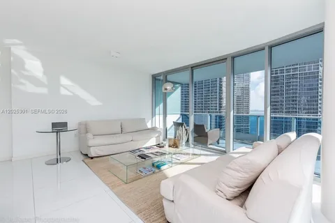 a living room with furniture and large windows