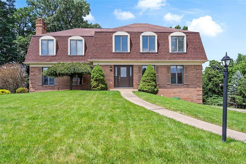 a front view of a house with yard and green space
