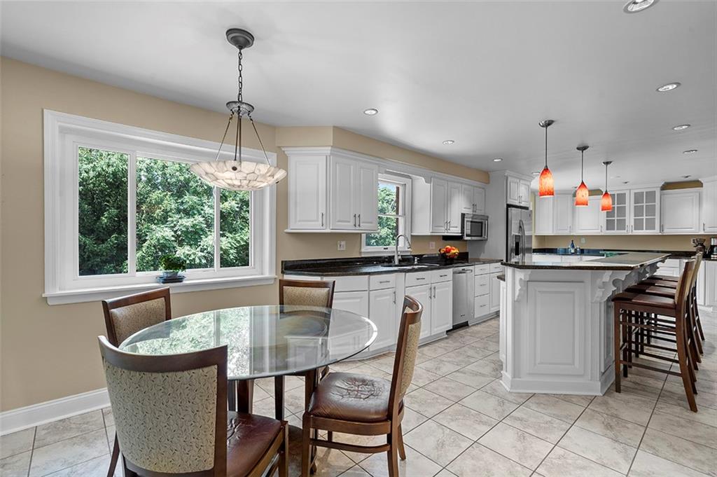 533 Woodland Road Pittsburgh, PA 15237 - Photo 13 of 43 a kitchen with kitchen island granite countertop a table chairs sink and cabinets