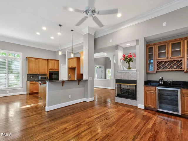an open kitchen view with fireplace and wooden floor