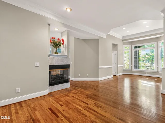 a view of an empty room with window and wooden floor