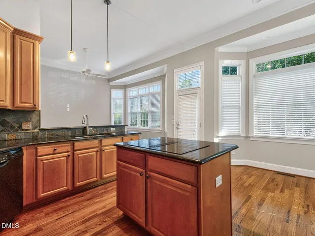 a kitchen with granite countertop a sink and wooden cabinets