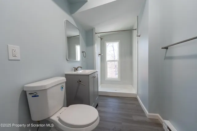 an empty room with wooden floor and window
