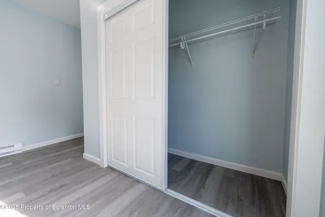 a view of walk in closet with wooden floor