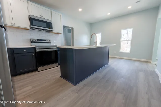 a bathroom with a toilet a sink and wooden floor