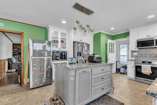 a kitchen with stainless steel appliances kitchen island granite countertop a refrigerator and stove