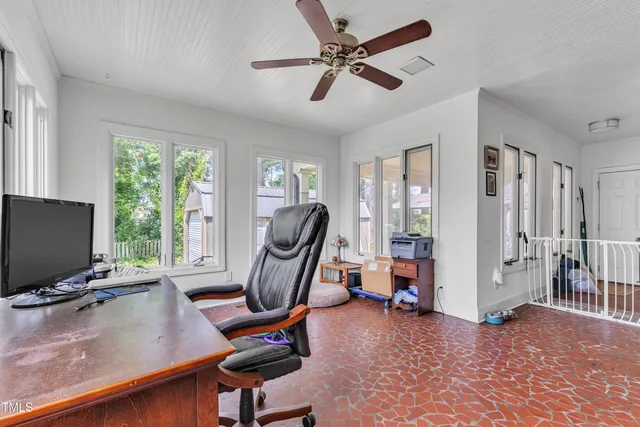 a view of a workspace with furniture and a window