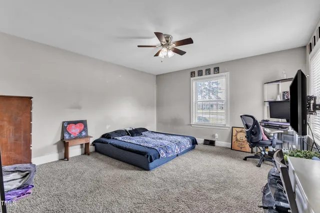 a bedroom with furniture a window and a ceiling fan